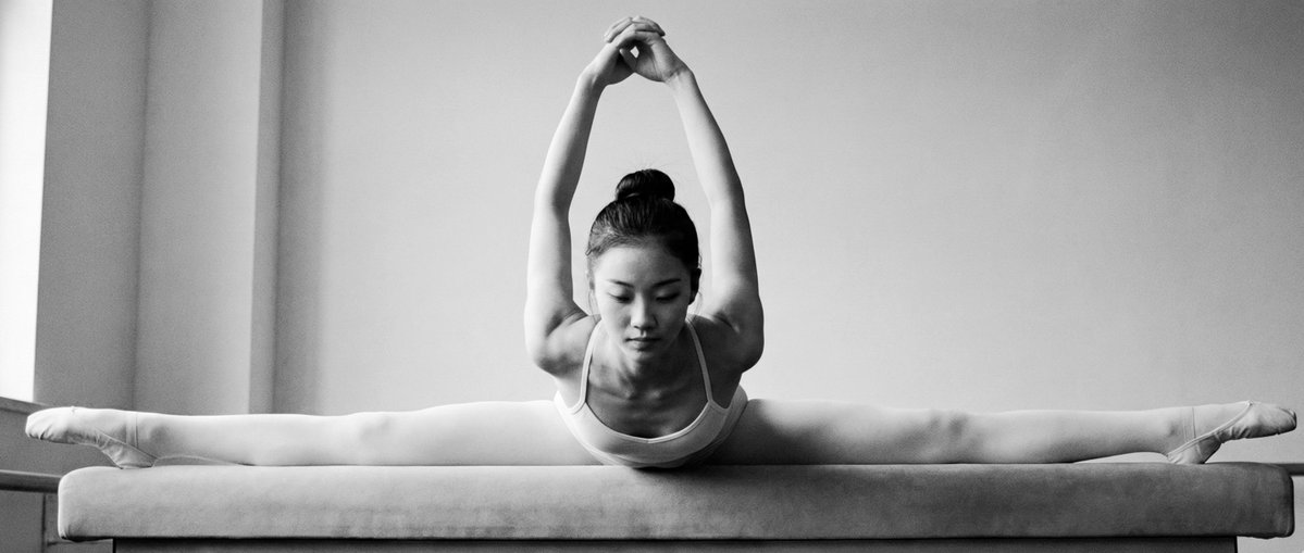 Young Asian Dancer Performing Split on Gymnastics Bench
